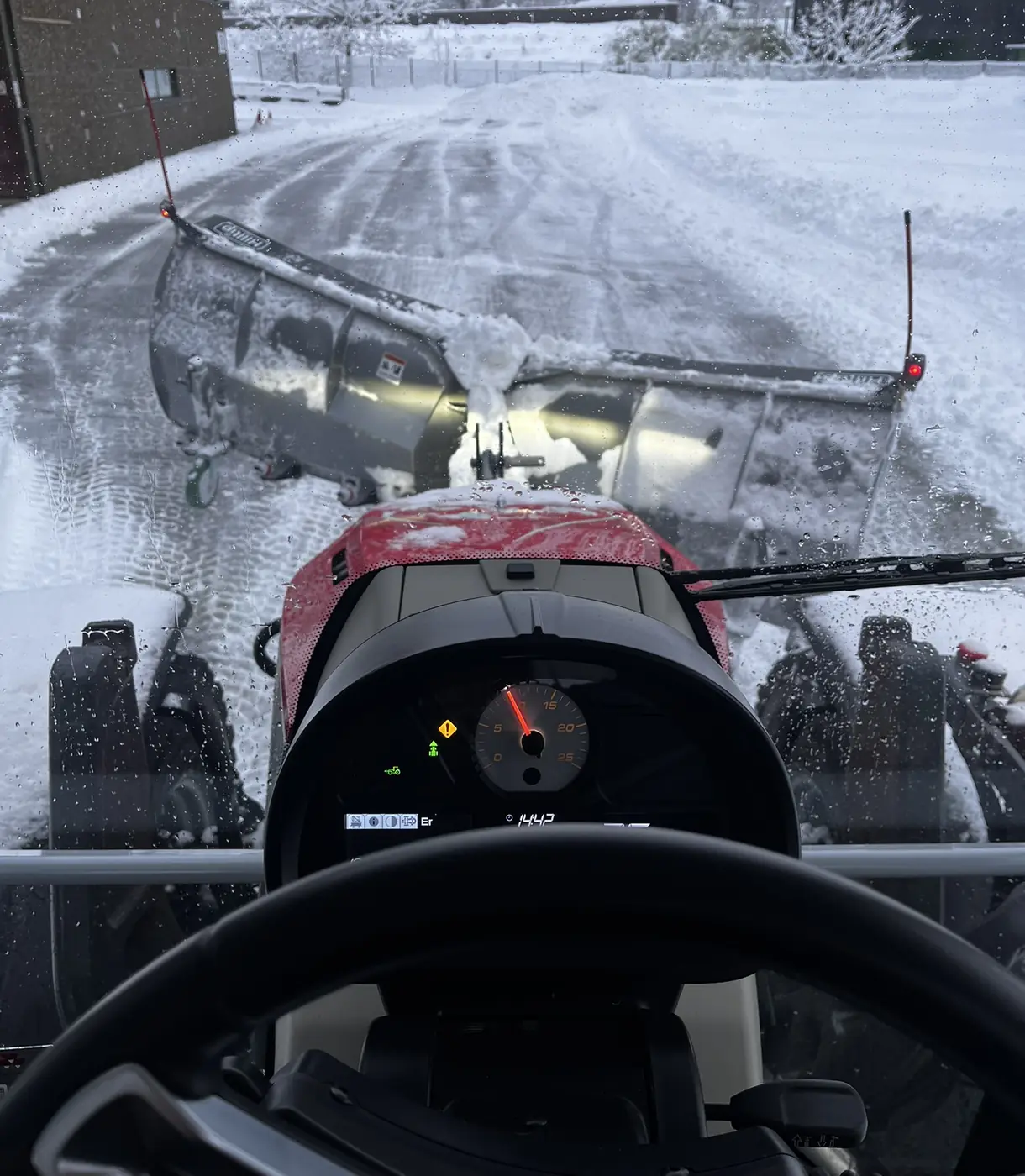 Brøyting med traktor og plog, sett fra førerhuset